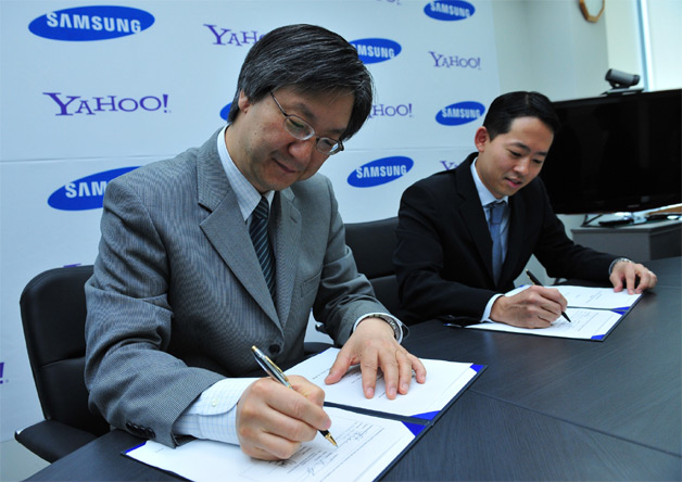 Dr. Ho Soo Lee, EVP, Media Solution Center, Samsung Electronics (L) and David Ko, SVP, Audience, Mobile and Local, North America, Yahoo! (R), sign strategic global partnership to pre-load Yahoo! services on tens of millions of Samsung devices. (Photo: Business Wire)